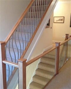glass gallery balustrade with customer painted forged steel wave spindles in silver up stairway