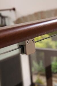 dark wood banister with clamped glass panel