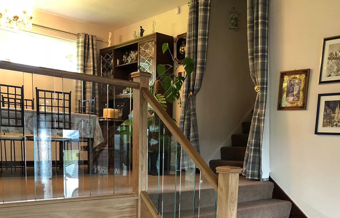 A staircase renovation in the Peak District with glass spindles and oak rails.