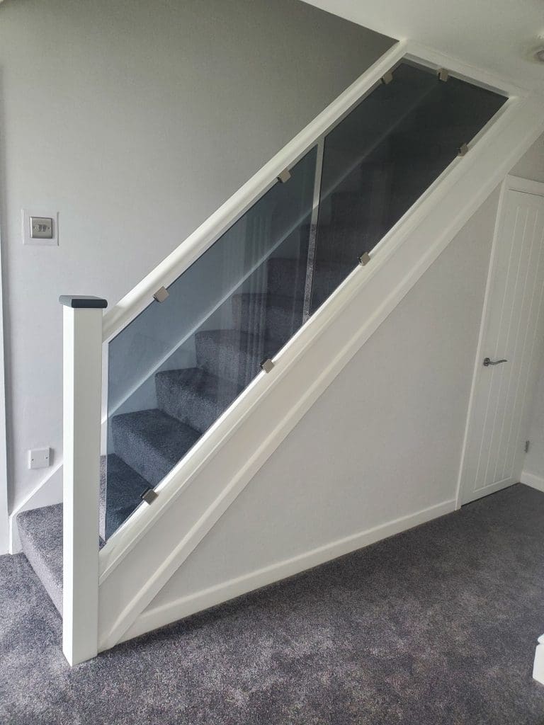 a white staircase renovation with grey glass in Rochdale