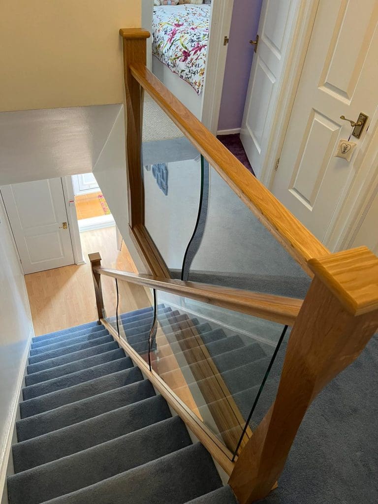 shaped glass panels and twisted newel posts in an Abbott-Wade staircase renovation in Solihull