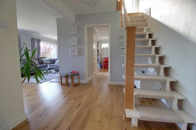 An open tread staircase refurbishment in Pangbourne is transformed with oak newel posts and shaped glass