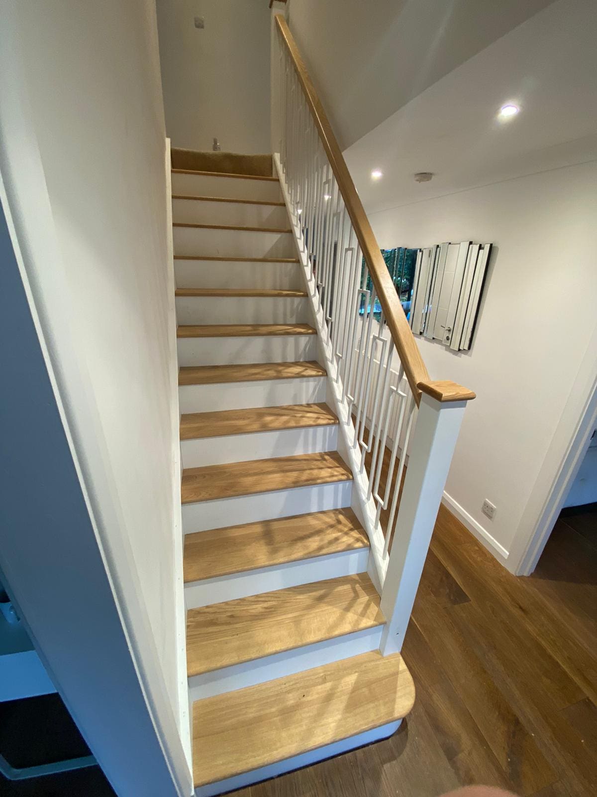 Our white metal Frame spindles pair with white newel posts and risers with contrasting oak treads & handrails create this light, bright staircase.