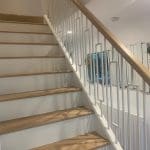 Our white metal Frame spindles pair with white newel posts and risers with contrasting oak treads & handrails create this light, bright staircase.