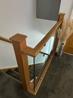 An oak staircase renovation in Brighouse with 10mm clamped glass panels.