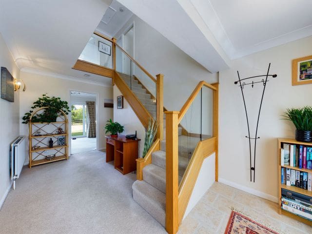 A hallway becomes bright and modern thanks to an oak & glass staircase renovation in Daventry.