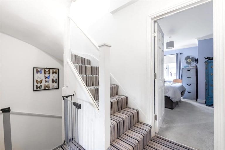 A modern bright white staircase renovation with embedded glass in Richmond upon Thames