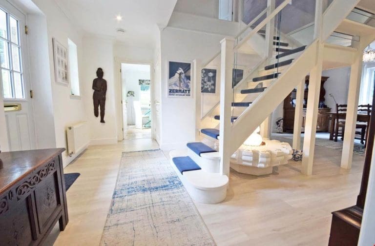 An impressive new open tread feature staircase in a dazzling white with a colourful carpet runner to add interest and detail.