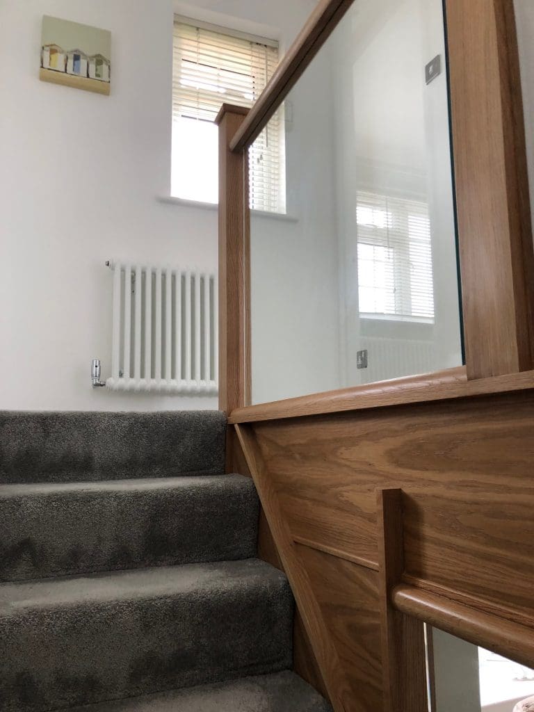A diminishing Essex staircase renovation uses oak & 10mm embedded glass to transform this living area in Billericay.