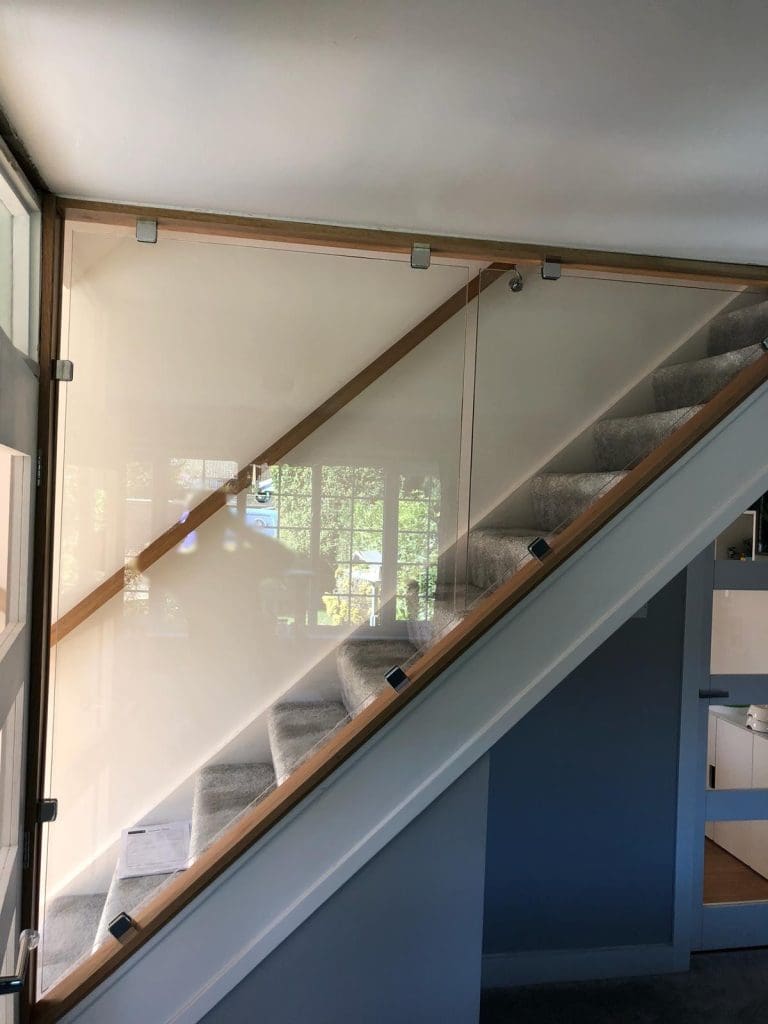 A diminishing glass staircase renovation in Wokingham including an oversized glass partition