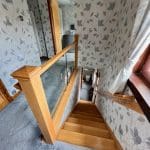 A dark staircase stuck between walls in Irvine is filled with light thanks to an Abbott-Wade glass & oak staircase renovation.