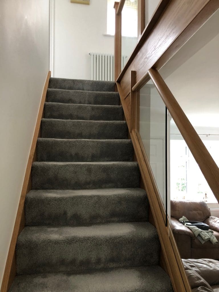 A diminishing Essex staircase renovation uses oak & 10mm embedded glass to transform this living area in Billericay.
