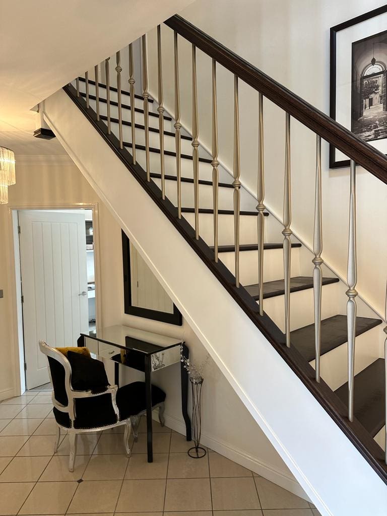 A contrasting two-tone black & white staircase renovation in Cronton with metal Buckingham spindles