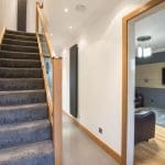 A contemporary oak & glass stair renovation in Up Holland with modern cube handrail and stainless steel newel caps.