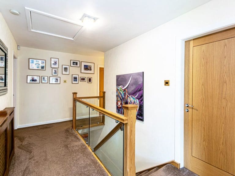 A stylish staircase renovation in Stockton Health with timeless newel posts & modern clamped glass.