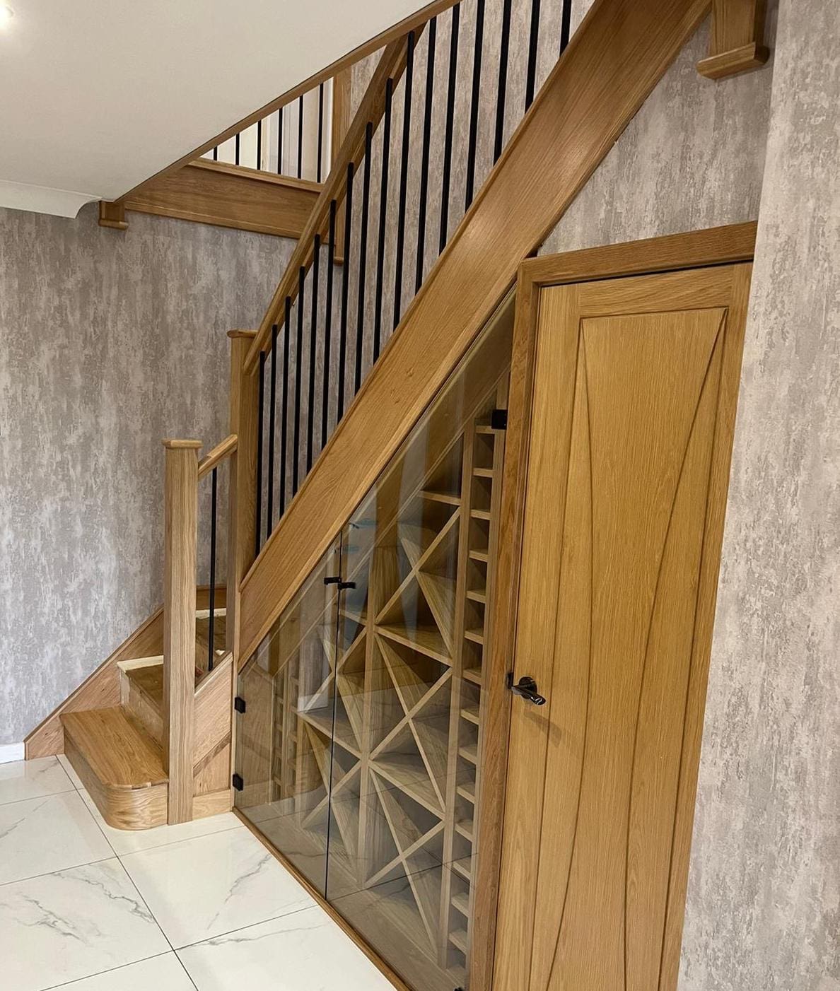 The stunning understairs wine rack housed behind glass is a stunning centrepiece to this Wigan home, framed against a truly beautiful staircase in Billinge, Wigan.