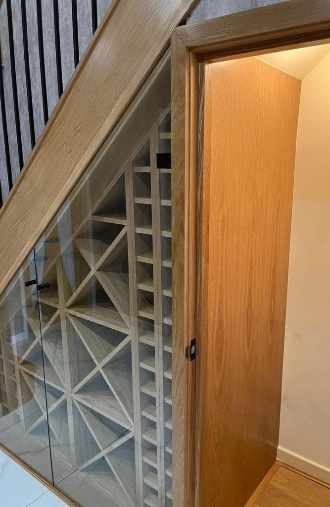 The stunning understairs wine rack housed behind glass is a stunning centrepiece to this Wigan home, framed against a truly beautiful staircase in Billinge, Wigan.