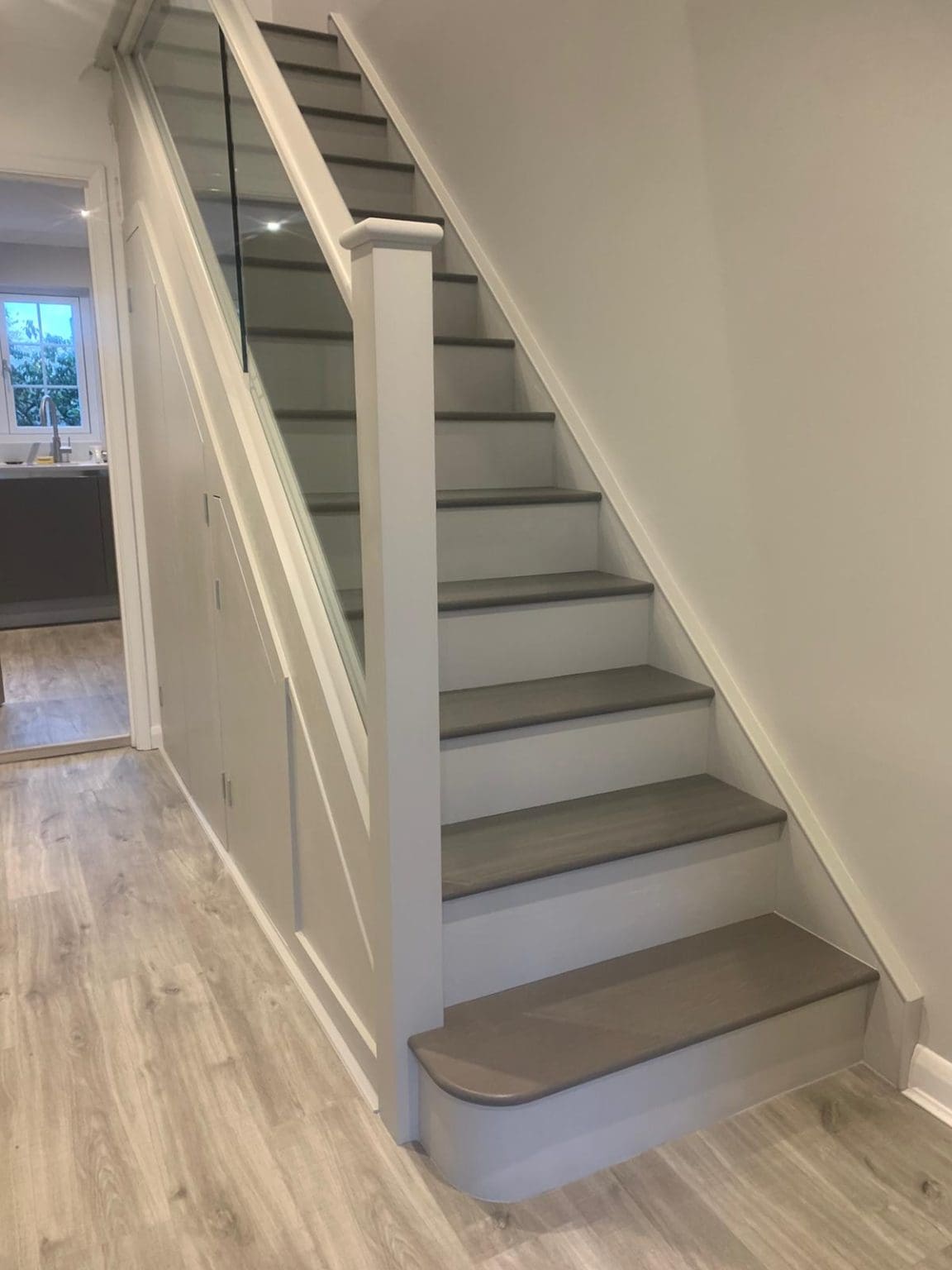 A modern 2-tone oak and glass painted staircase refurbishment installed in Leatherhead.