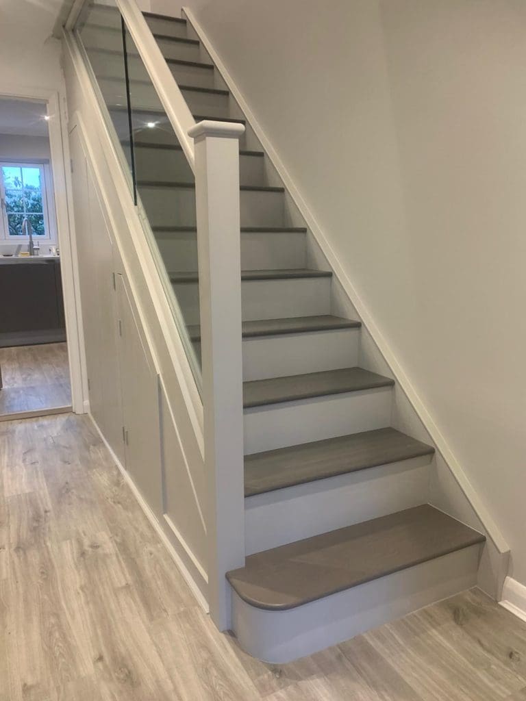 A modern 2-tone oak and glass painted staircase refurbishment installed in Leatherhead.