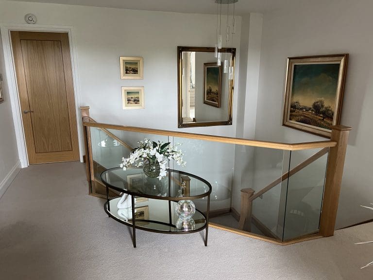 A grand branching feature staircase with oak & embedded glass in Brackley transforms this Northamptonshire home. Mirror, furniture,