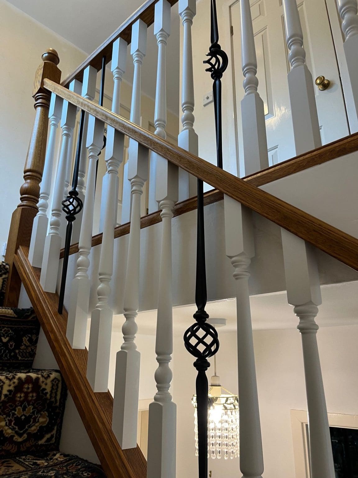 A traditionally styled stained oak staircase in Neston combine wooden spindles with forged steel in this Wirral home.