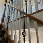 A traditionally styled stained oak staircase in Neston combine wooden spindles with forged steel in this Wirral home.
