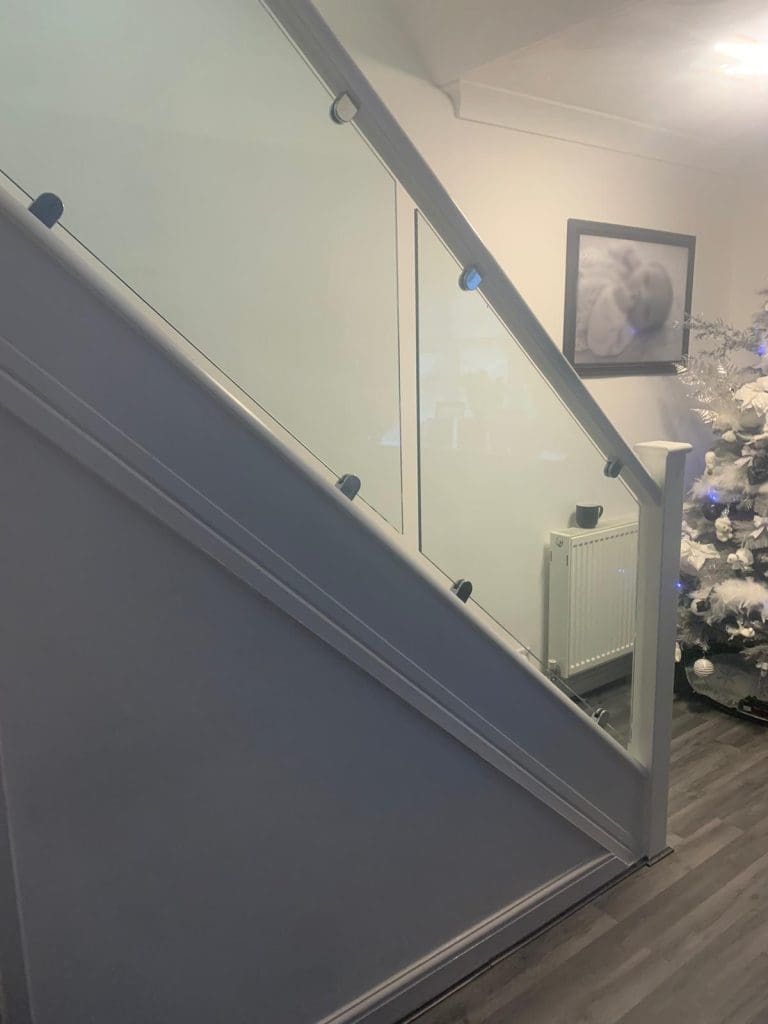A white staircase renovation in St Helens with 10mm glass panels secured with stainless steel clamps. Christmas, white,