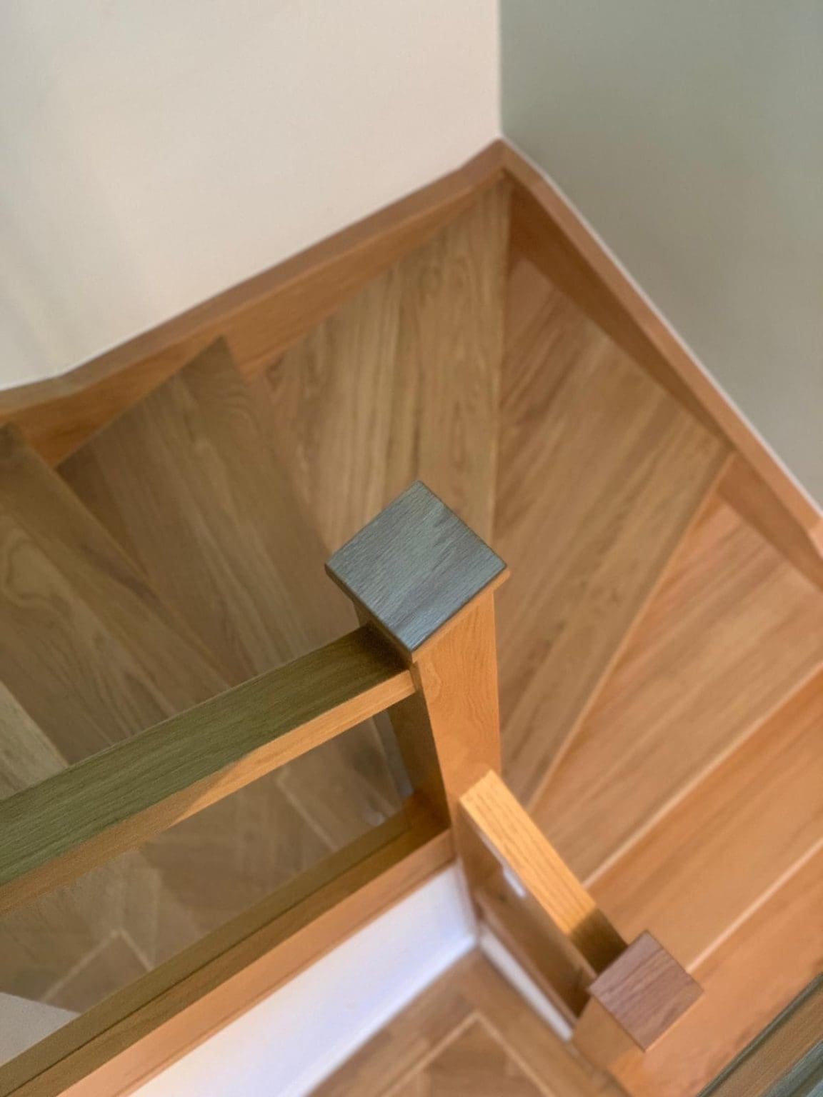A modern glass staircase renovation with lots of clean straight edges and the warm hues of natural oak overlooking the Cumbrian coastline.